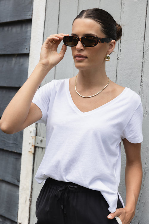 model wears a white tee with black pants