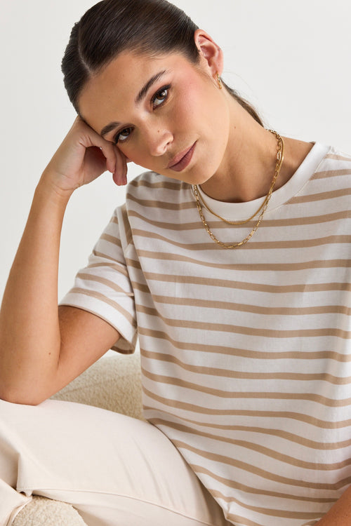 model wears a white and natural stripe tee