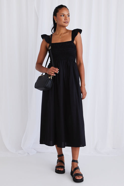 model wears a black dress with black sandals