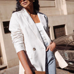 model wears beige linen blazer with blue jeans and a brown handbag