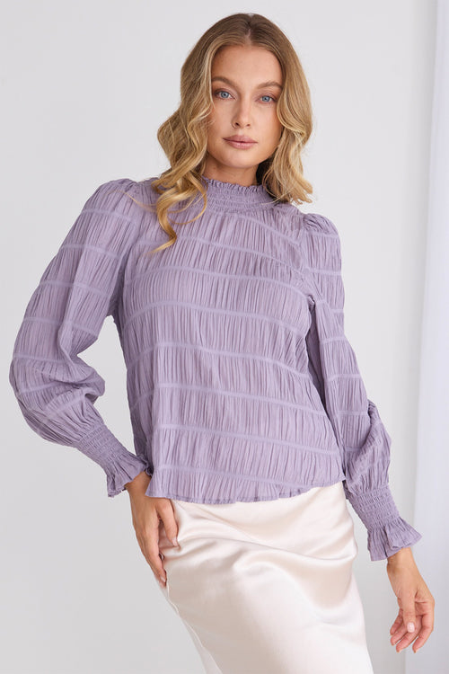  model wears a purple long sleeve top