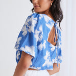 model in blue floral crop top and white skirt