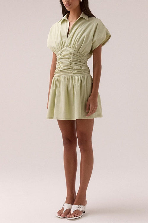 model wears a green ruched dress