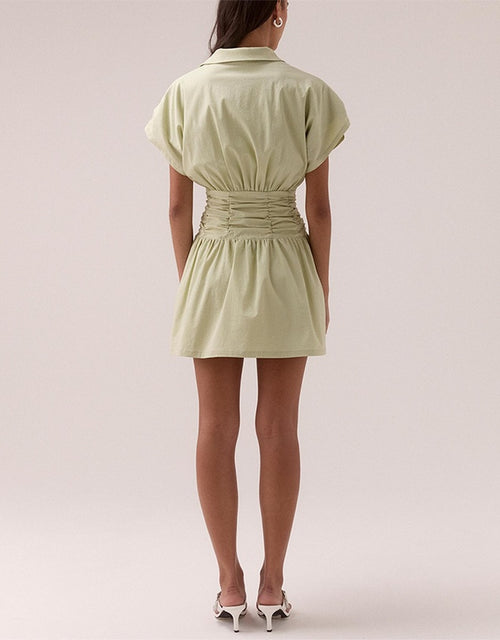 model wears a green ruched dress