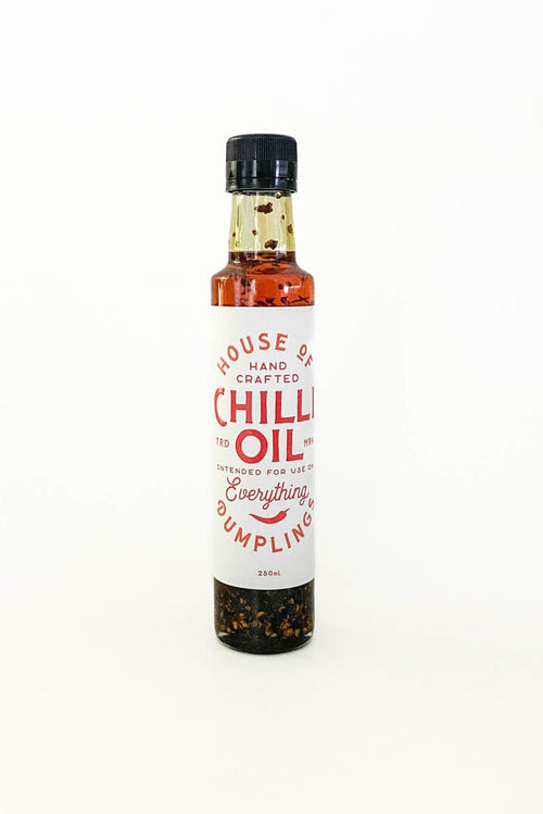 A small glass bottle of House of Dumpling Chilli Oil with a white label and black cap, standing on a white background.