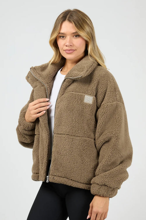 Woman wearing a brown fleece jacket on a white background