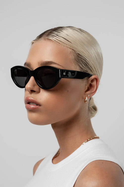 Woman wearing black sunglasses with a plain background