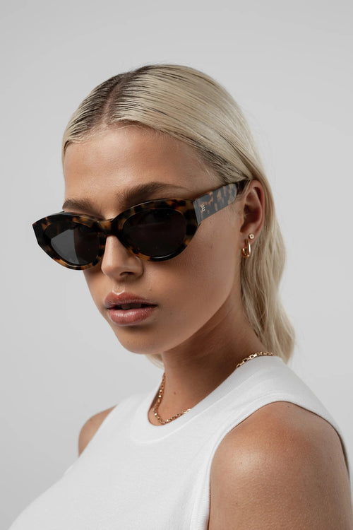 Woman wearing sunglasses with a neutral background