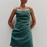 Woman wearing a green dress against a plain background