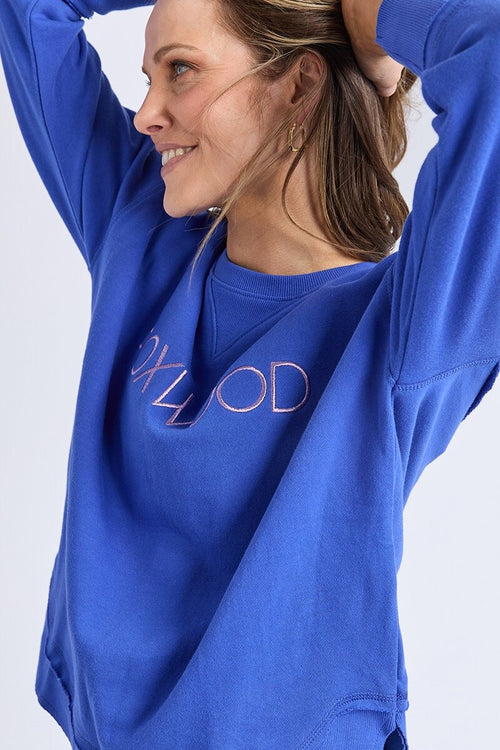 Women wearing blue crewneck and blue jeans