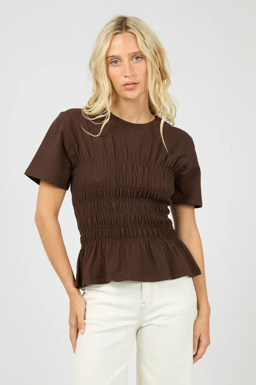 Woman wears a brown ruched top