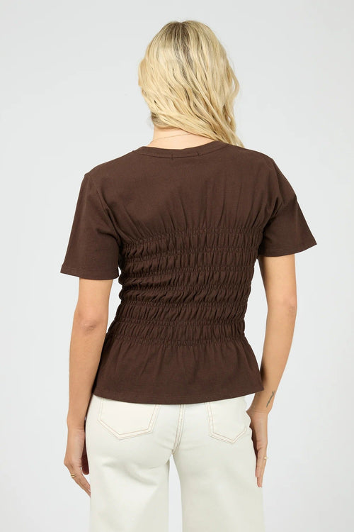 Woman wears a brown ruched top