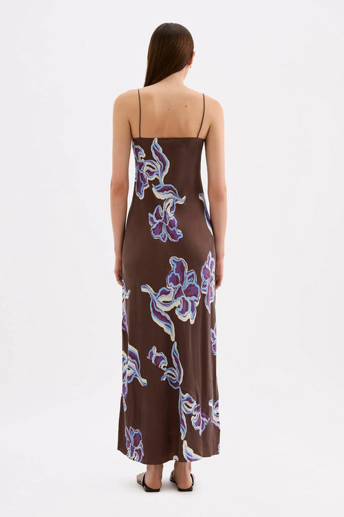 Brown floral maxi slip dress with thin straps, featuring a blue and cream abstract floral print and a straight neckline.