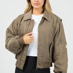 Woman wearing a brown jacket on a white background
