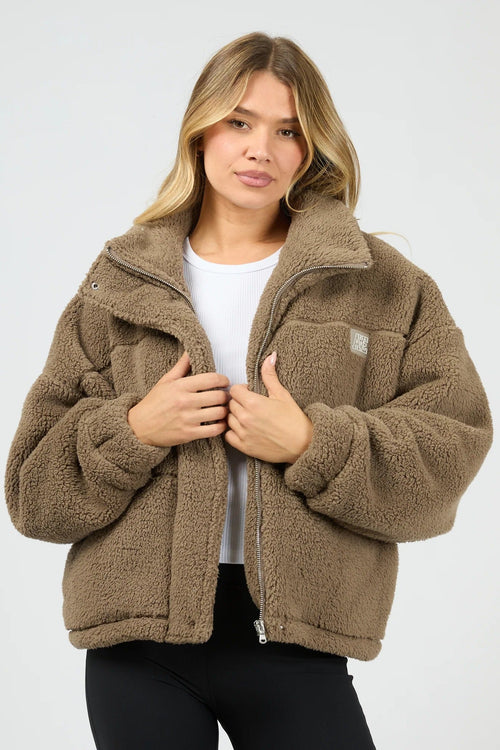 Woman wearing a brown fleece jacket on a white background