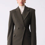Woman wearing a dark green suit on a white background