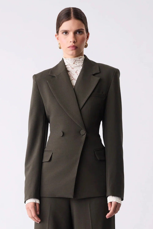 Woman wearing a dark green suit on a white background