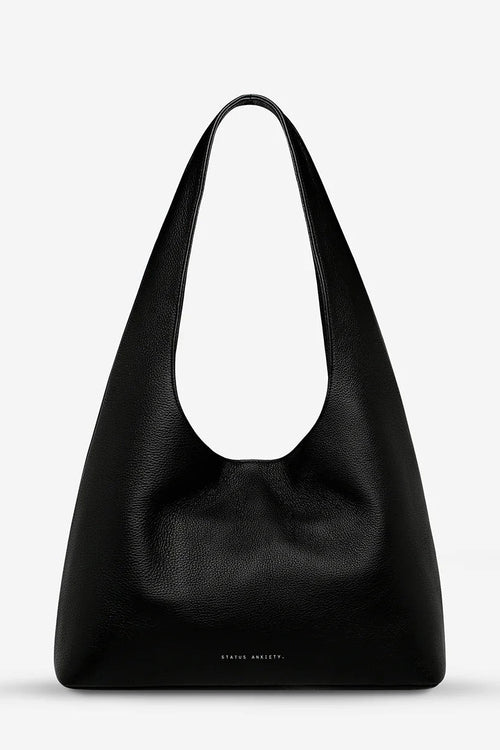 Black leather handbag on a light gray background