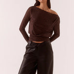 Woman wearing a brown off-shoulder top and black pants against a white background
@col_Shade