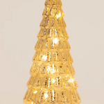 A small, textured gold Christmas tree light with warm white LED lights glowing inside, set against a plain light beige background.