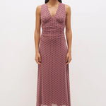 Woman wearing a pink polka dot dress on a white background