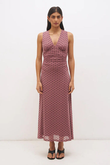 Woman wearing a pink polka dot dress on a white background