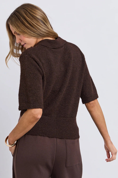 Woman wearing a brown sweater and pants on a white background