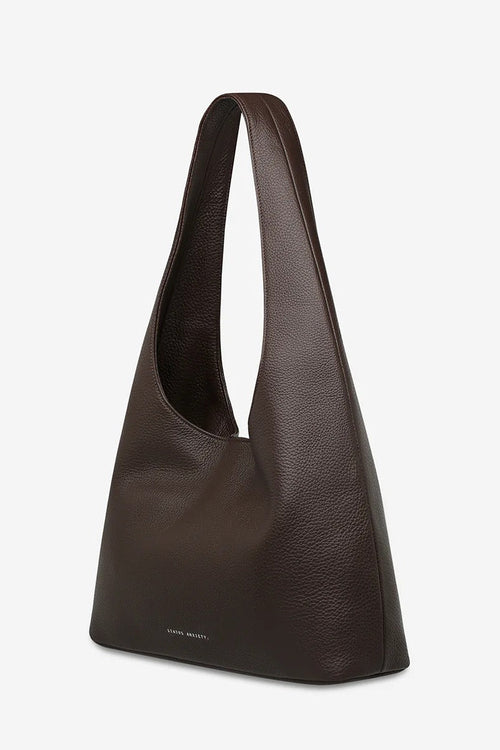 Brown leather handbag on a light gray background