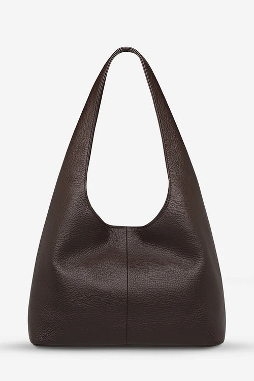 Brown leather handbag on a light gray background
