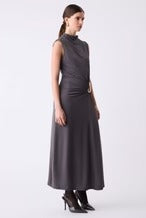 Woman wearing a black sleeveless dress with a belt on a white background