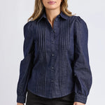 Woman wearing a dark blue blouse with puffed sleeves on a white background