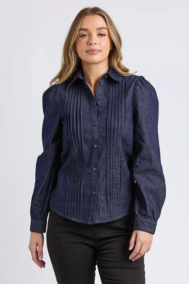 Woman wearing a dark blue blouse with puffed sleeves on a white background