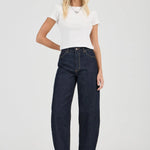 Woman wearing a white t-shirt and dark blue jeans on a white background