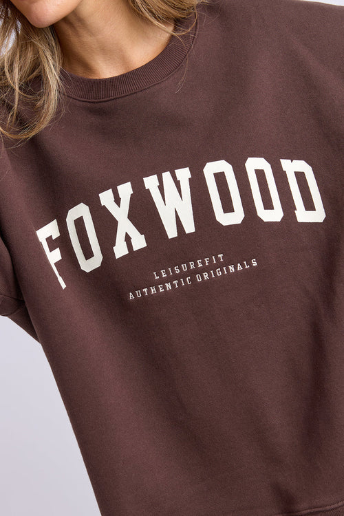 Brown sweatshirt with 'FOXWOOD' printed on it against a light gray background