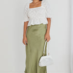 model wears white top and green satin maxi skirt