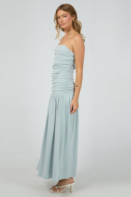 woman wears a blue ruched maxi dress