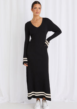 Model wears a long sleeve black maxi dress