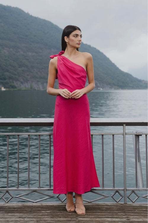 model wears a one shoulder pink midi dress