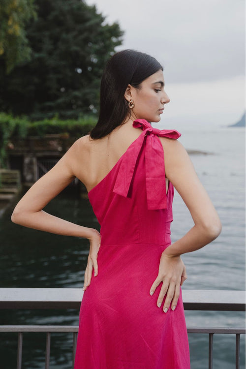 model wears a one shoulder pink midi dress