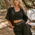 model wearing mtaching black button up shirt and shorts set with black singlet underneath