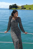 model wears black long sleeve floral midi dress on a boat