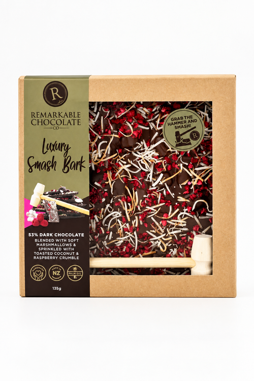 A boxed chocolate bar set from Remarkable Chocolate, featuring a kraft paper package with a clear window showing dark chocolate pieces mixed with red berries and white chocolate shavings.