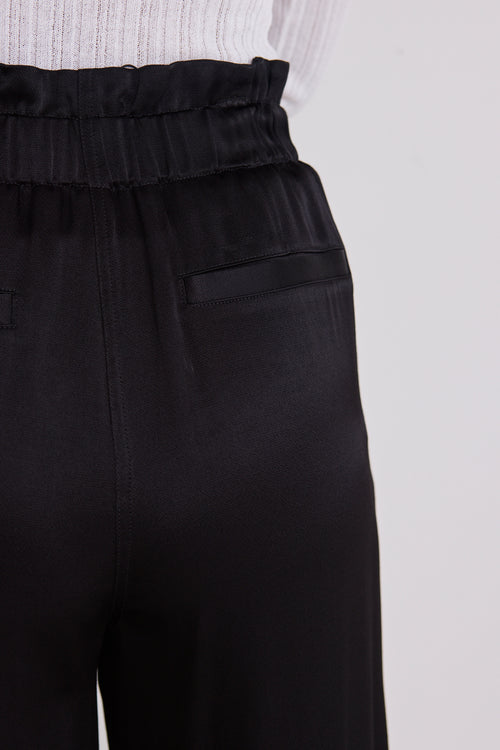 model wears a black satin pant