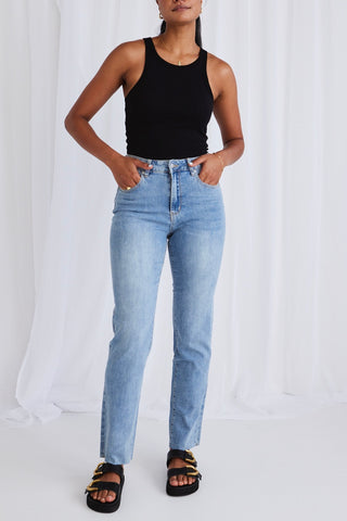model wears light blue jeans with black tank top 