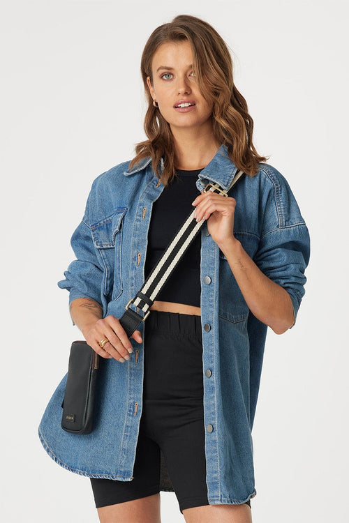 model wears black bag with black and white strap