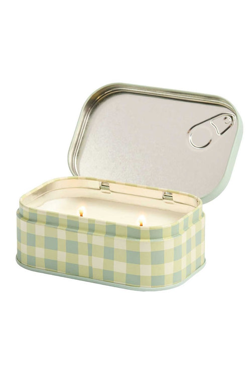 A rectangular tin candle with an open lid, featuring a pale green and white gingham pattern on the exterior and a silver-toned metal interior with two lit wicks.