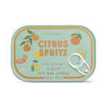 A Paddywax Citrus Spritz soy wax candle in a rectangular tin with rounded corners, featuring a light mint green background with illustrations of oranges, lemons, and cocktail glasses, plus a silver pull tab on the right side.