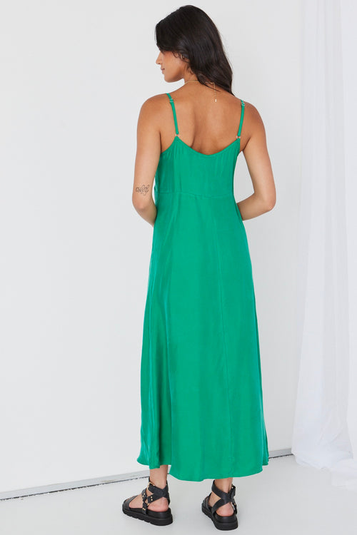 model wears long green cupro maxi dress and black sandals
