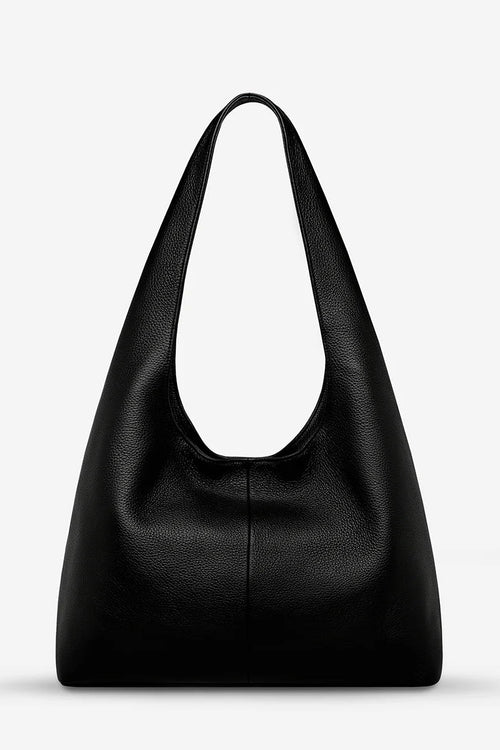 Black leather handbag on a light gray background