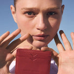 Model holding red card wallet 